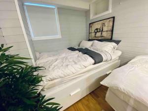 Cama blanca en habitación con ventana en Sentralt og hjemmekoselig, en Narvik