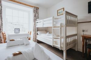 a bedroom with two bunk beds and a desk at Y Pengwern in Ffestiniog