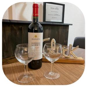 a bottle of wine and two glasses on a table at Appartements Zur Auszeit in Waldkirchen
