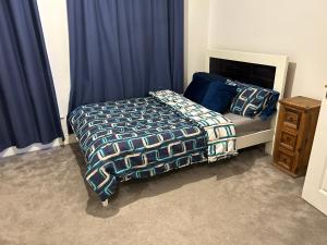 a bedroom with a bed and blue curtains at Heyward mews holiday homes in Dublin