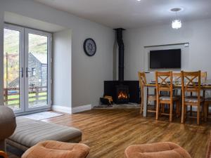 a living room with a table and a fireplace at Striding Edge Cottage in Glenridding
