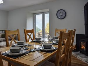格倫里丁的住宿－Striding Edge Cottage，一间带木桌和壁炉的用餐室