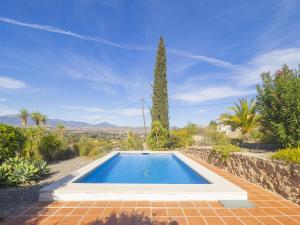 a swimming pool in a garden with a tree at Cubo's La Maison de Mily in Villafranco de Guadalhorce