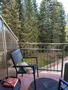una sedia a dondolo su un balcone con alberi sullo sfondo di Sana Ski apartment 313A in Flora, Borovets a Borovets