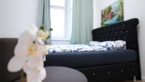 a bedroom with a bed and a couch and a window at Modern Double room JS in Vienna
