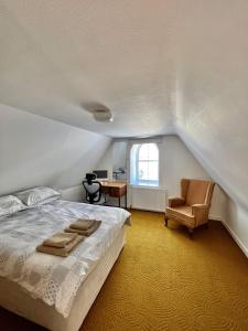a bedroom with a bed and a chair and a desk at Victorian Chapel House in Arisaig