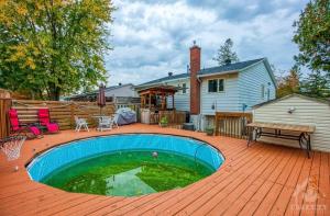 a backyard with a swimming pool on a wooden deck at CastleRooms Homestay in Ottawa