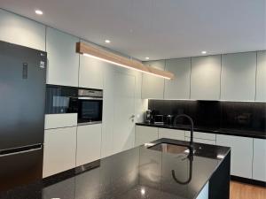 a kitchen with white cabinets and a black counter top at Casa da Arda, Afife in Armada