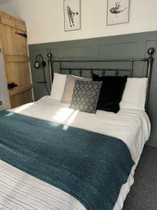 Hurst cottage, a cosy 2 bed cottage in Dorset في Stalbridge: غرفة نوم بسرير كبير مع بطانية زرقاء