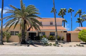 a house with palm trees in front of it at Beachside Villa at Boca Catalina in Palm-Eagle Beach