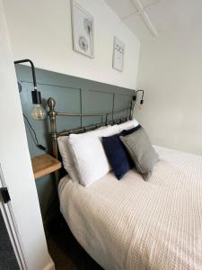 um quarto com uma cama com uma cabeceira azul em Hurst cottage, a cosy 2 bed cottage in Dorset em Stalbridge