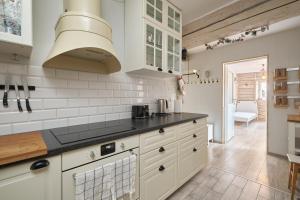 a kitchen with white cabinets and black counter tops at Apartament Empujon Sokołowsko in Sokołowsko