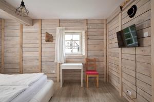 Schlafzimmer mit einem Bett, einem TV und einem Stuhl in der Unterkunft Apartament Empujon Sokołowsko in Sokołowsko