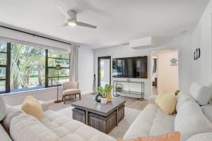 een woonkamer met een witte bank en een tafel bij Paradise Palms House in Delray Beach