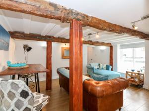 ein Wohnzimmer mit einem Bett und einem Tisch in der Unterkunft Leveret Cottage in Docking