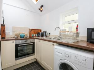 a kitchen with a washing machine and a sink at Leveret Cottage in Docking