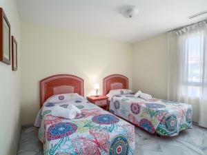 two beds sitting next to each other in a room at Fantastic beachfront apartment in Estepona +28 photos