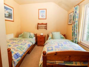 una camera da letto con due letti e una finestra di The Cottage a Pwllheli