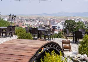 a wooden boardwalk with chairs and tables and a view of a city at Hotel Panorama in Gjakove