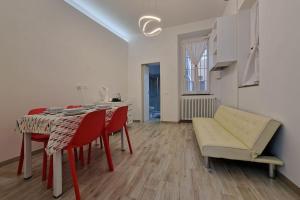 ein Wohnzimmer mit einem Tisch und roten Stühlen in der Unterkunft La Casa dei Sogni: Bilocale Chic a Pavia in Pavia