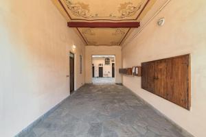 einen leeren Flur mit Kassettendecke und Flur in der Unterkunft La Casa dei Sogni: Bilocale Chic a Pavia in Pavia
