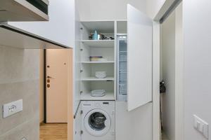 eine Waschmaschine und ein Trockner in einer weißen Waschküche in der Unterkunft La Casa dei Sogni: Bilocale Chic a Pavia in Pavia