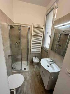 ein Bad mit einer Dusche, einem Waschbecken und einem WC in der Unterkunft La Casa dei Sogni: Bilocale Chic a Pavia in Pavia