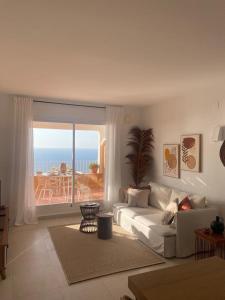 a living room with a couch and a view of the ocean at Amazing vue mer CASAZAZA in Benitachell +11 photos