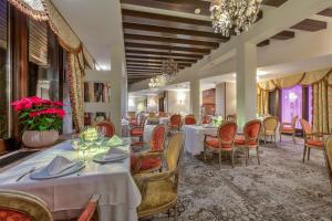 a dining room with tables and chairs and a chandelier at Alpin ApartHotel 2302 in Poiana Brasov