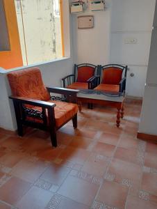 three chairs and a table in a room at Yasin Guest house in Puducherry +1 photo