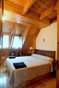 セルセディリャにあるLa Casita de la Sierra Cercedillaの木製の天井の客室で、ベッドルーム1室(大型ベッド1台付)