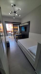 - une chambre avec un lit blanc et une salle à manger dans l'établissement Studio 110 Maravilhoso Vista Mar Piscina Aquecida, à Matinhos