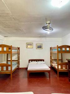 Zimmer mit 3 Etagenbetten und einer Decke in der Unterkunft La Casa Blanca Binoclutan Beach Resort in Botolan