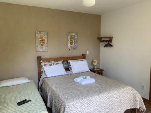 a bedroom with two beds with towels on them at Pousada Pe da Serra in Tiradentes