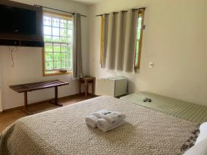 a bedroom with a bed with two towels on it at Pousada Pe da Serra in Tiradentes +84 photos