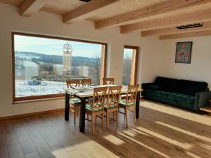 a dining room with a table and chairs and a large window at Kuźnia Nowica in Uście Gorlickie