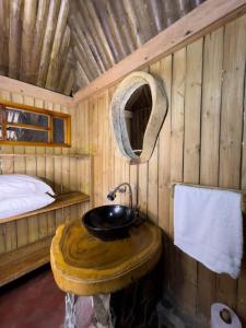 a bathroom with a sink in a wooden cabin at Tayrona Cachaco River Ecohostal in El Zaino