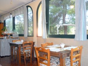 comedor con 2 mesas, sillas y ventanas en B&B Santa Venardia Gallipoli, en Gallipoli