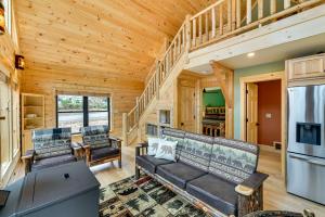 a log cabin living room with couches and a refrigerator at Modern Cabin with Hot Tub and Sacandaga Lake Access! in Broadalbin