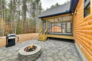 a patio with a fire pit and a house at Modern Cabin with Hot Tub and Sacandaga Lake Access! in Broadalbin