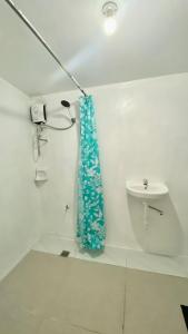 a bathroom with a shower curtain and a sink at La Casa Blanca Binoclutan in Botolan +40 photos