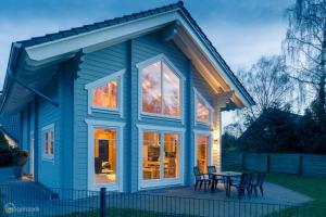 a blue house with a table and chairs at Ferienhaus Nordic in Lembruch