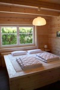 a large bed in a room with two windows at Ferienhaus Nordic in Lembruch