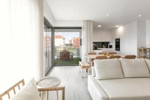 a living room with a white couch and a table at Consolação Wave Beach House in Atouguia da Baleia