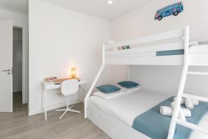 a white bedroom with a bunk bed and a desk at Consolação Wave Beach House in Atouguia da Baleia +17 photos