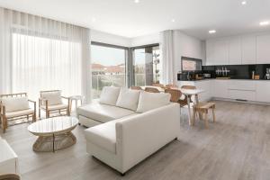 a living room with a white couch and a table at Consolação Wave Beach House in Atouguia da Baleia