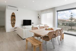 a living room with a table and a couch at Consolação Wave Beach House in Atouguia da Baleia