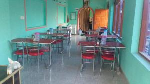 a room with tables and chairs in a restaurant at SPOT ON Sharma's Kitchen & Home Stay in Bajaura