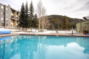a swimming pool with blue water in front of a building at Keystone Lodge & Spa, A Vail Resorts Property in Keystone