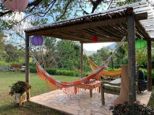 uma rede de descanso sob uma pérgula num jardim em Pousada Pe da Serra em Tiradentes